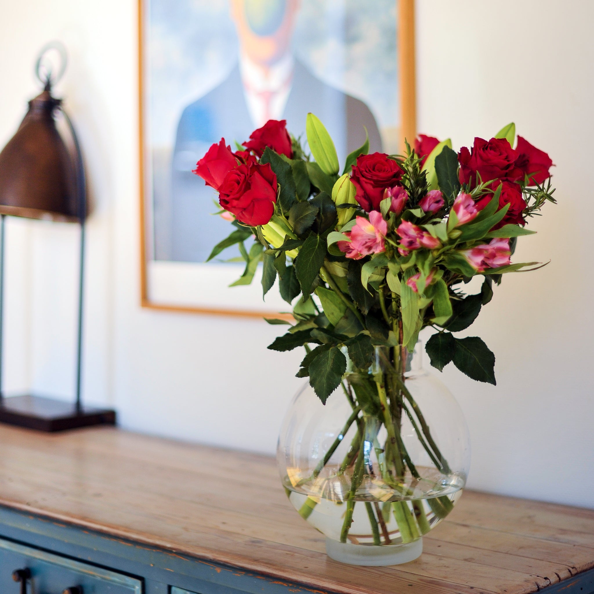 Vackert blomsterarrangemang med rosor och blandade blommor